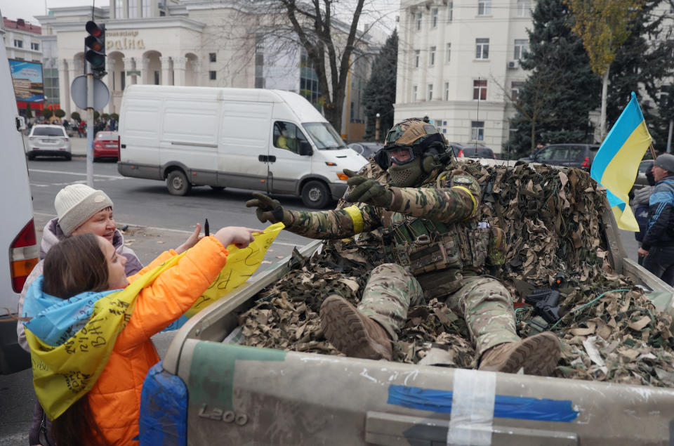 Two women greet a Ukrainian soldier as they celebrate the liberation of their town in Kherson, on November 13, 2022, amid Russia's invasion of Ukraine. - On November 11, 2022, Russia said it had pulled back more than 30,000 troops in the southern region, with Ukrainian President Volodymyr Zelensky declaring Kherson 