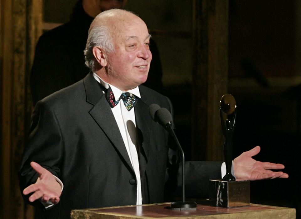 A man in a tuxedo at a podium.