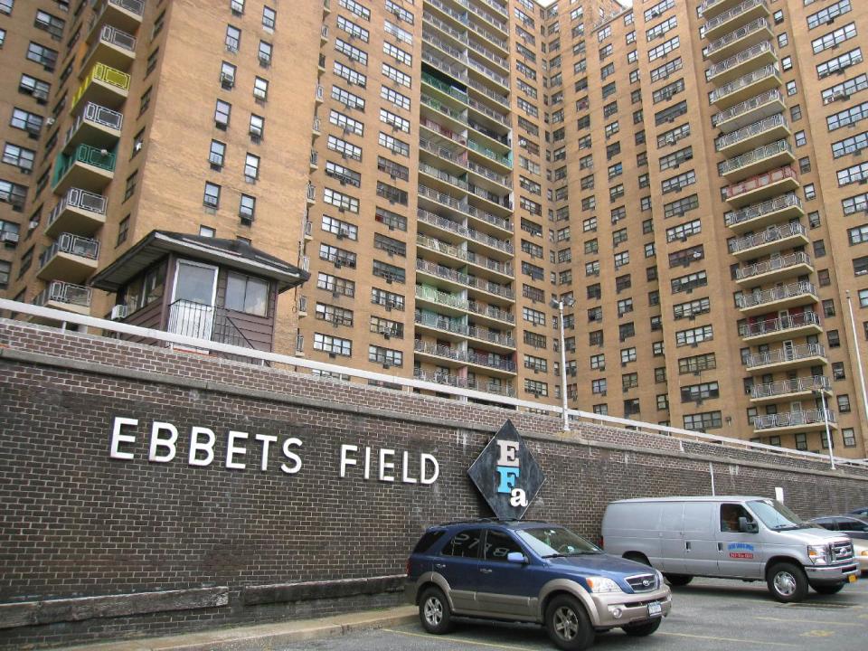 FILE - This April 7, 2013 file image shows the site of the Brooklyn Dodgers’ ballpark, Ebbets Field, which was torn down after the Dodgers moved to Los Angeles in 1957 and is today an apartment complex in the Crown Heights neighborhood. A stone in the wall says “This is the former site of Ebbets Field” while a faded sign in the courtyard says “No ball playing.” There are many destinations of interest to baseball fans around the country outside ballparks from museums and statues to historic homes. (AP Photo/Beth J. Harpaz, File)