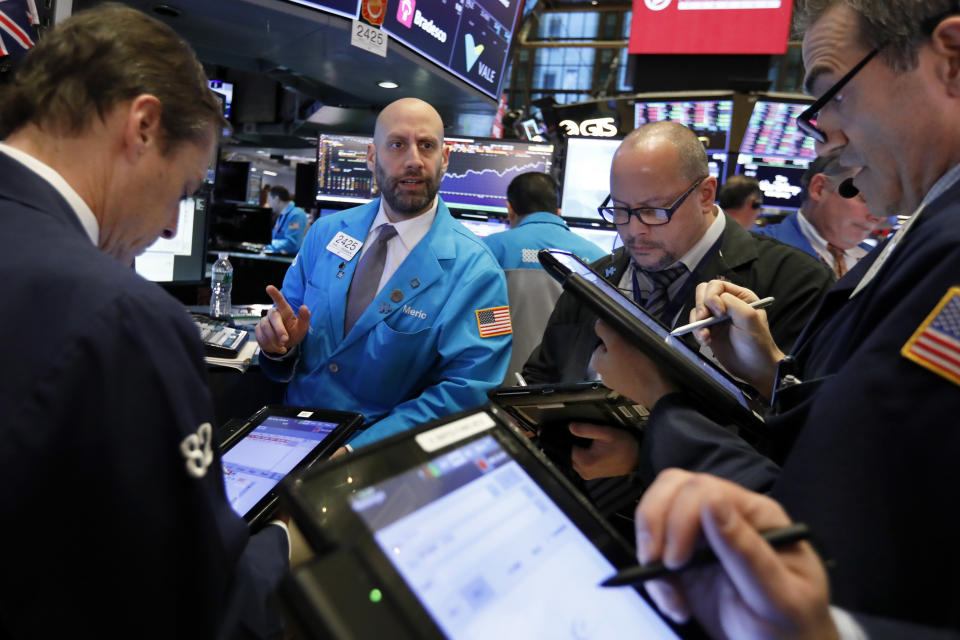 Specialists Meric Greenbaum, second left, works with traders at his post on the floor of the New York Stock Exchange, Thursday, Nov. 8, 2018. Stocks are opening modestly lower on Wall Street as the market gives back some of its big gains from the day before. (AP Photo/Richard Drew)