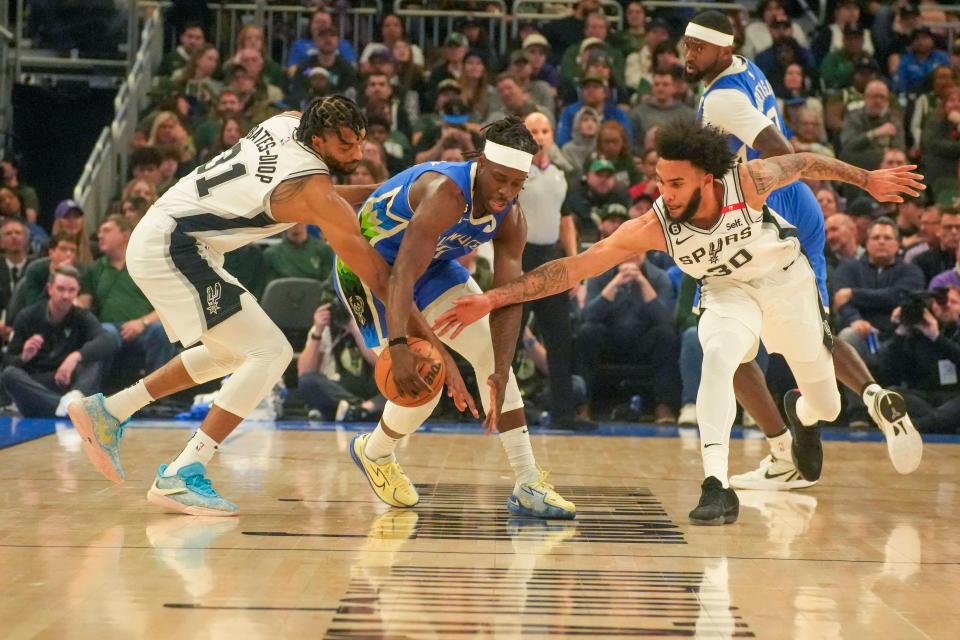 Bucks guard Jrue Holiday tries to keep the ball away from Spurs forwards Keita Bates-Diop (left) and Julian Champagnie during the first half Wednesday night at Fiserv Forum.