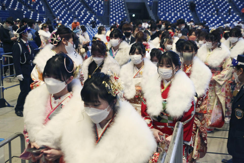 Women who have just turned and will be 20 years old this year clad in Japan's traditional kimono outfits wear face masks to protect against the spread of the coronavirus in order to attend a ceremony to celebrate Coming of Age Day in Yokohama Monday, Jan. 10, 2022. (AP Photo/Koji Sasahara)