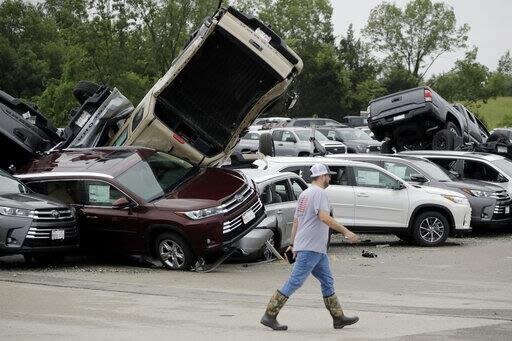 Worker pictured walking past damaged cars at a Toyota dealership in Jefferson City.