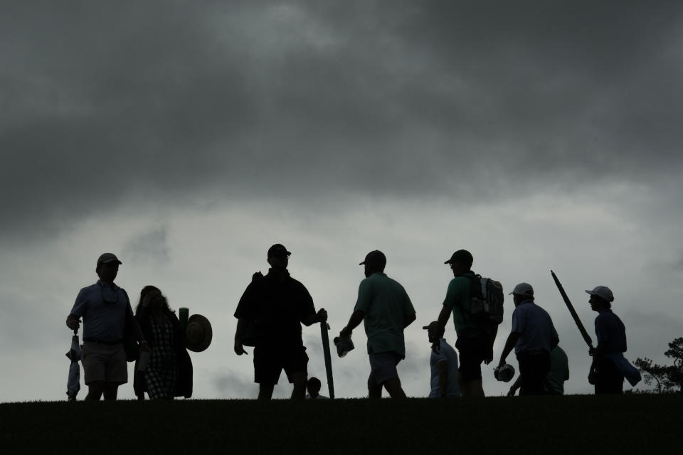 Patrons depart the course during a weather delay in the second round of the Masters golf tournament at Augusta National Golf Club on Friday, April 7, 2023, in Augusta, Ga. (AP Photo/Charlie Riedel)