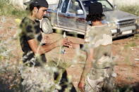 A Tajammu al-Ezza brigade fighter hands over a mortar shell to a fellow fighter as they prepare to fire towards forces loyal to Syria's president Bashar Al-Assad located on Al-Zlakiet checkpoint in Hama countryside May 6, 2015. REUTERS/Mohamad Bayoush