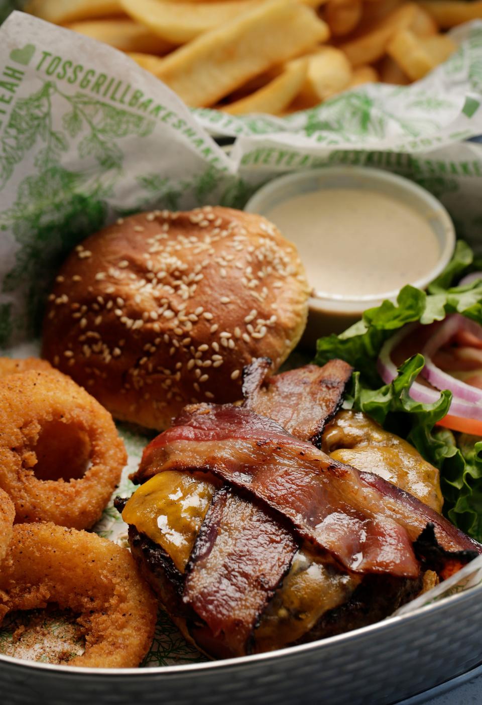 The Loop's Bacon Cheddar Burger is made with applewood smoked bacon and cheddar cheese, and includes a side of onion rings.