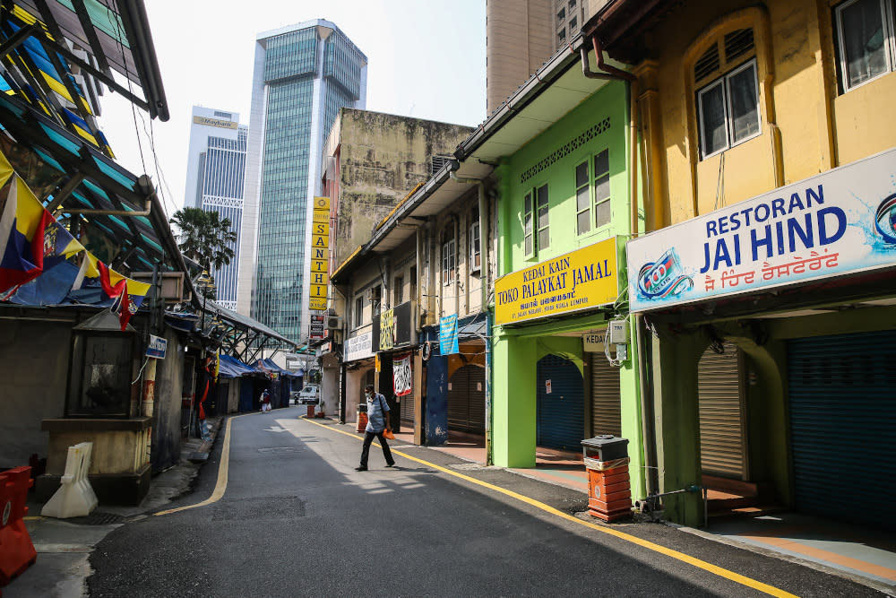 A man walks in front of a row of closed shops in Kuala Lumpur March 21, 2020. — Picture by Yusof Mat Isa