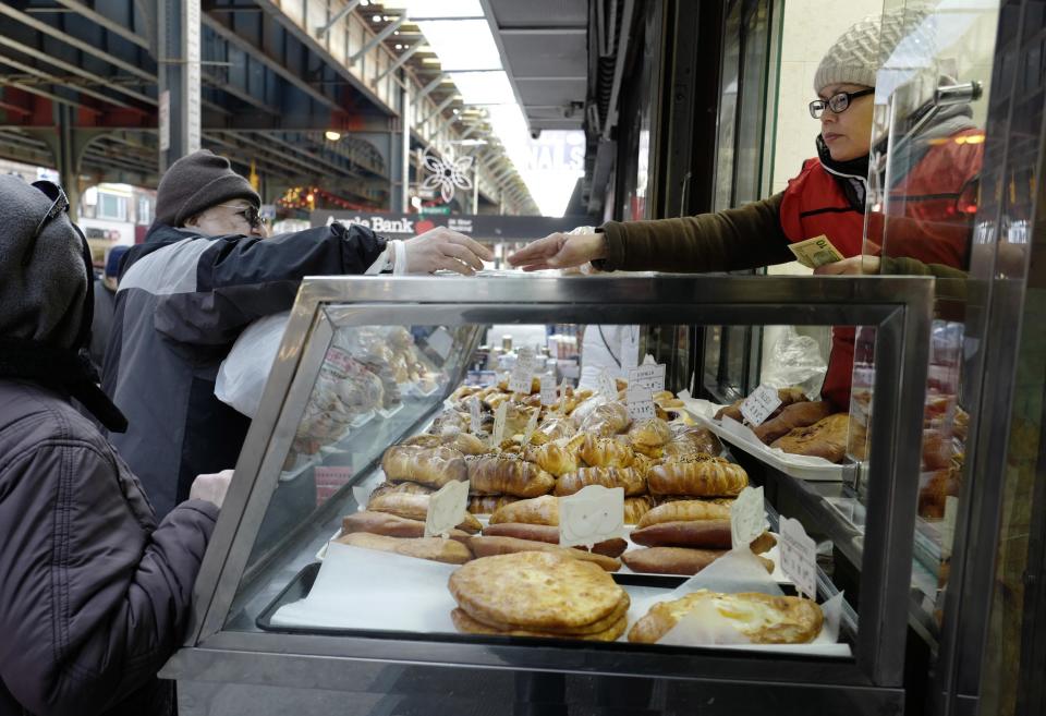 In this Dec. 16, 2016 photo, a clerk leans through a bakery window to make change for a customer in the Brooklyn borough of New York. Donald Trump enjoyed a high-level of support among migrants from the former Soviet Union living in this oceanside community. (AP Photo/Mark Lennihan)