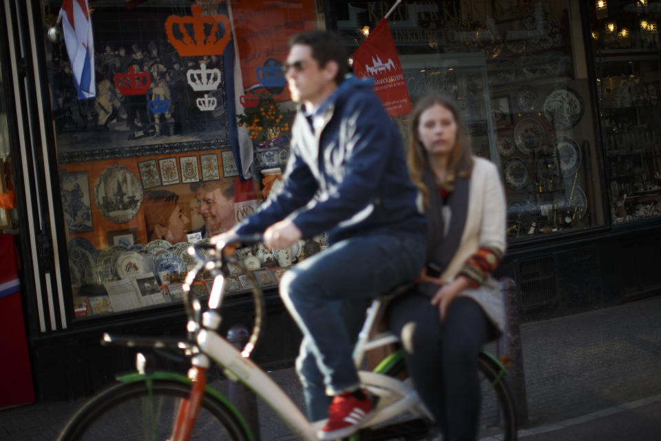 An image of Crown Prince Willem Alexander and souvenirs with The Netherlands flag colors decorates a shop window in Amsterdam, Netherlands Sunday, April 28, 2013. Queen Beatrix announced she will relinquish the crown on April 30, 2013, after 33-years of reign, leaving the monarchy to her son Crown Prince Willem Alexander. (AP Photo/Daniel Ochoa de Olza)