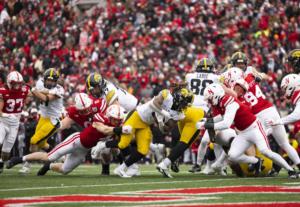 Nebraska's Luke Reimer, left, and John Bullock, right, stop Iowa's Jaziun Patterson short of the goal line during the first half of an NCAA college football game Friday, Nov. 24, 2023, in Lincoln, Neb. (AP Photo/Rebecca S. Gratz)