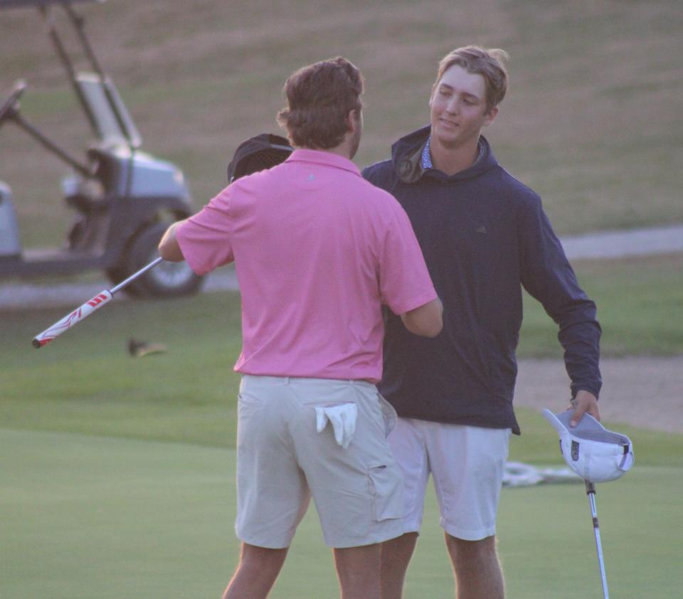 Ferris State University teammates Caleb Bond (right) and Shayne Beaufait embrace following the second playoff hole in the Northern Michigan Open on Sunday night.