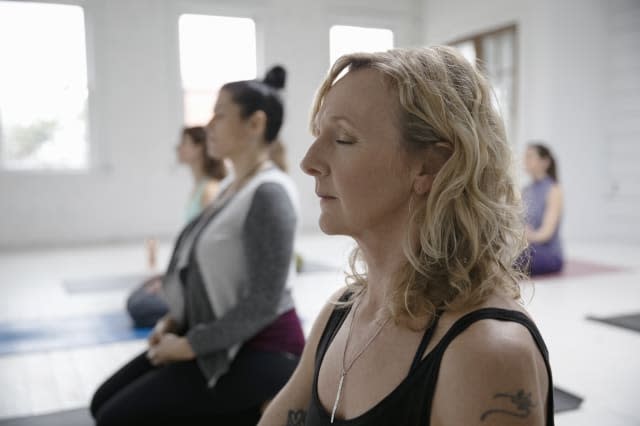 Serene woman meditating in yoga class