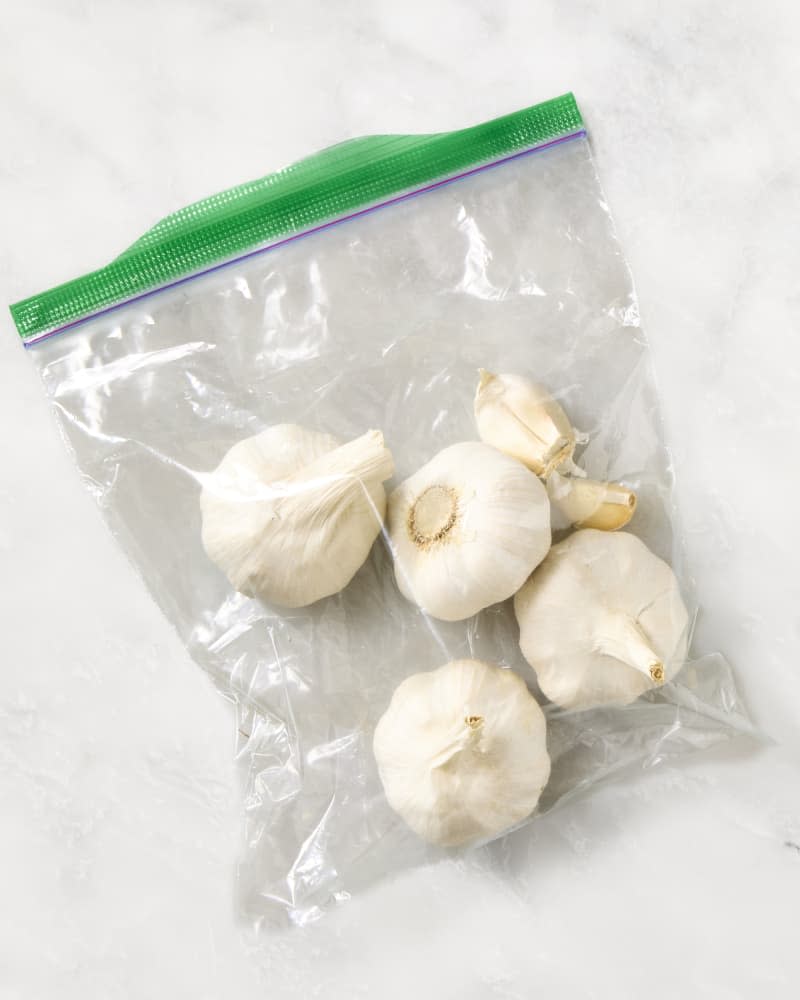 garlic in a ziplock bag on a marble surface.