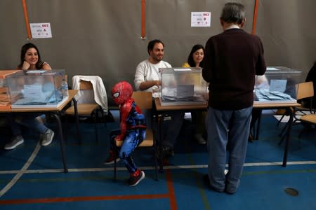 FILE PHOTO: Child dressed as Spider-Man waits for his family to vote in Madrid