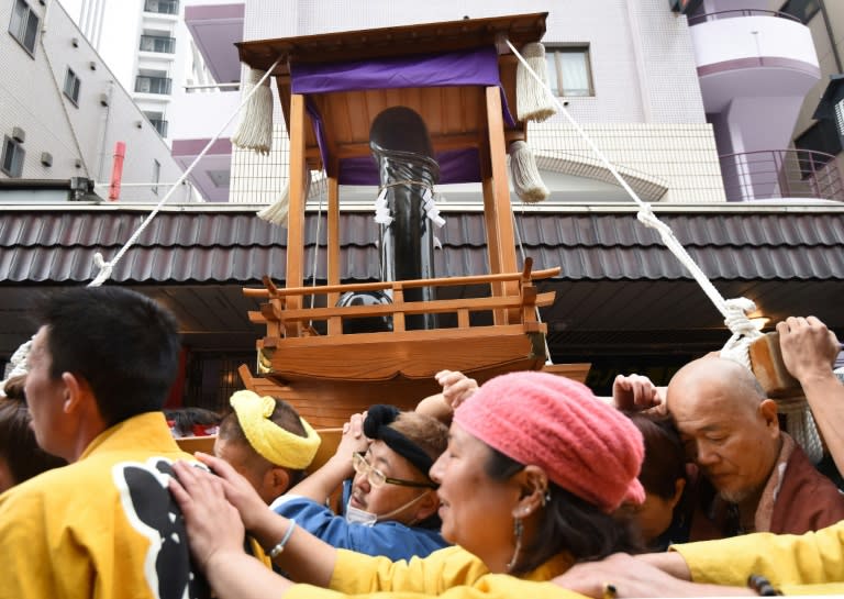 A portable shrine bearing a giant phallus is carried through the streets of Kawasaki, a suburb of Tokyo, on April 3, 2016