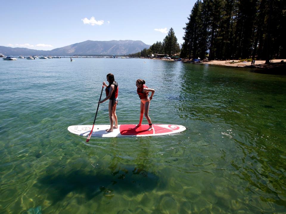 Two tourists paddle board on Lake Tahoe in 2019.