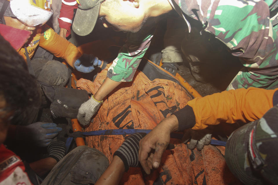 Rescuers carry the body of a hiker killed in the eruption of Mount Marapi in Agam, West Sumatra, Indonesia, Wednesday, Dec. 6, 2023. The surprise weekend eruption killed nearly two dozens climbers and injured several others, officials said. (AP Photo/Ade Yuandha)