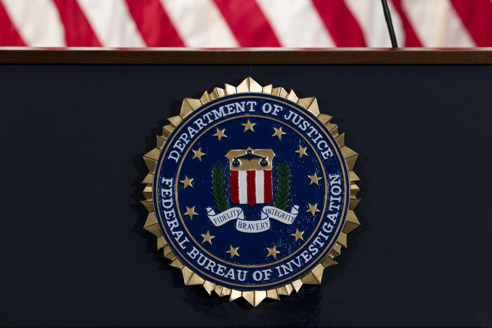 FILE - In this June 14, 2018, file photo, the FBI seal is seen before a news conference at FBI headquarters in Washington. The FBI says it is getting serious about sexual harassment in its ranks, starting a 24/7 tip line, doing more to help accusers and taking a tougher stand against agents found to have committed misconduct. (AP Photo/Jose Luis Magana, File)