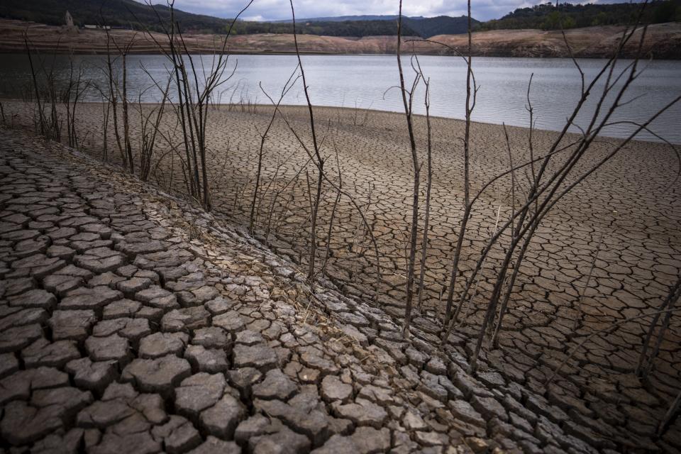 FILE - The dry cracked earth is visible near the Sau reservoir, north of Barcelona, Spain, Tuesday, April 18, 2023. Spain suffered the biggest losses from wildfires of any European Union country last year amid a record-hot 2022, and there is worry that this year’s fire season could also be bad. (AP Photo/Emilio Morenatti)