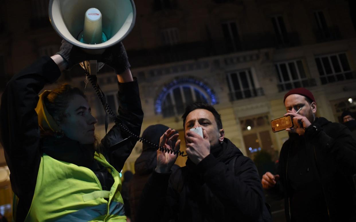 A protester speaks in a megaphone during a demonstration in front of the Bouffes du Nord theatre in Paris  - AFP