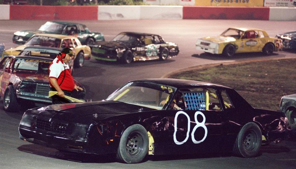 Steve Brookens, pit steward at Barberton Speedway, goes on the track to give directions to a driver in a jam during a break in the racing on July 26, 1997.