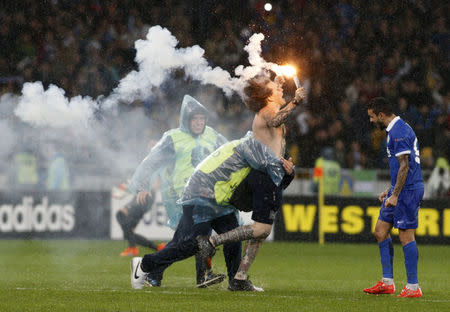 Security attempts to stop a supporter of Dnipro Dnipropetrovsk who ran onto the pitch to celebrate the victory over Napoli in the Europa League semi-final second leg soccer match at the Olympic stadium in Kiev, Ukraine, May 14, 2015. REUTERS/Valentyn Ogirenko