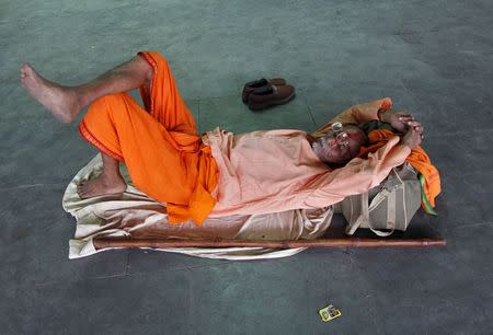 A Sadhu or a Hindu holyman sleeps at a railway station on a hot summer day in Allahabad, India, May 27, 2015. REUTERS/Jitendra Prakash