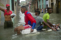 <p>Residents float down a flooded street in Havana atop a large piece of styrofoam. There were no immediate reports of deaths in Cuba, a country that prides itself on its disaster preparedness, but authorities were trying to restore power and clear roads. (AP Photo/Ramon Espinosa) </p>