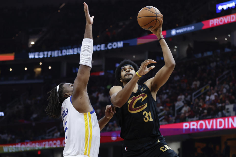 Cleveland Cavaliers center Jarrett Allen (31) shoots over Golden State Warriors forward Kevon Looney, left, during the first half of an NBA basketball game, Sunday, Nov. 5, 2023, in Cleveland. (AP Photo/Ron Schwane)