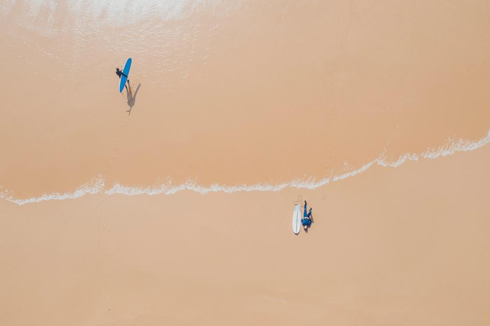 Surfers on the beach in Sagres - getty