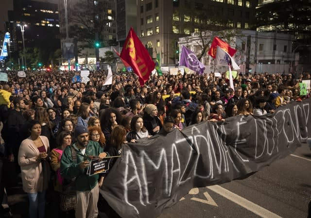 Demonstrators march holding a banner with a message that reads in Portuguese: “The Amazon belongs to the people” 