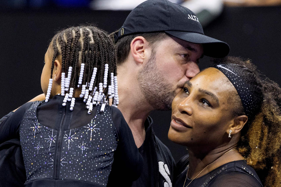 Serena Williams (right) gets a kiss from her husband Alexis Ohanian (center) while holding their daughter Olympia after winning her first-round match at the 2022 U.S. Open. (Corey Sipkin / AFP - Getty Images)