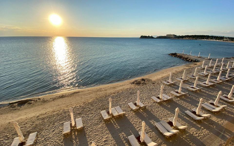 rows of empty white sunbeds on bed