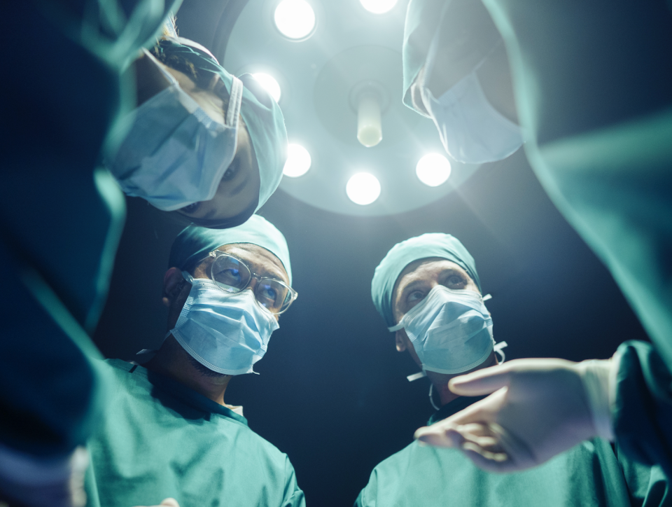 Medical team performing surgery, viewed from patient's perspective