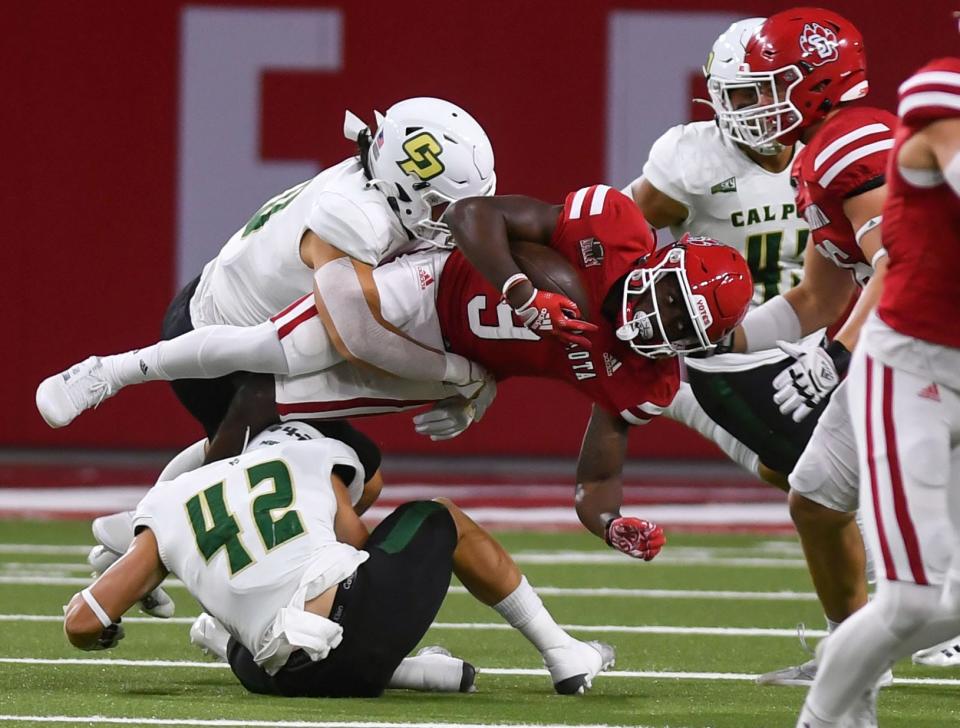 South Dakota’s Wesley Eliodor is turned sideways by a tackle from Cal Poly’s David Meyer in a football game on Saturday, September 17, 2022, at the DakotaDome in Vermillion. 