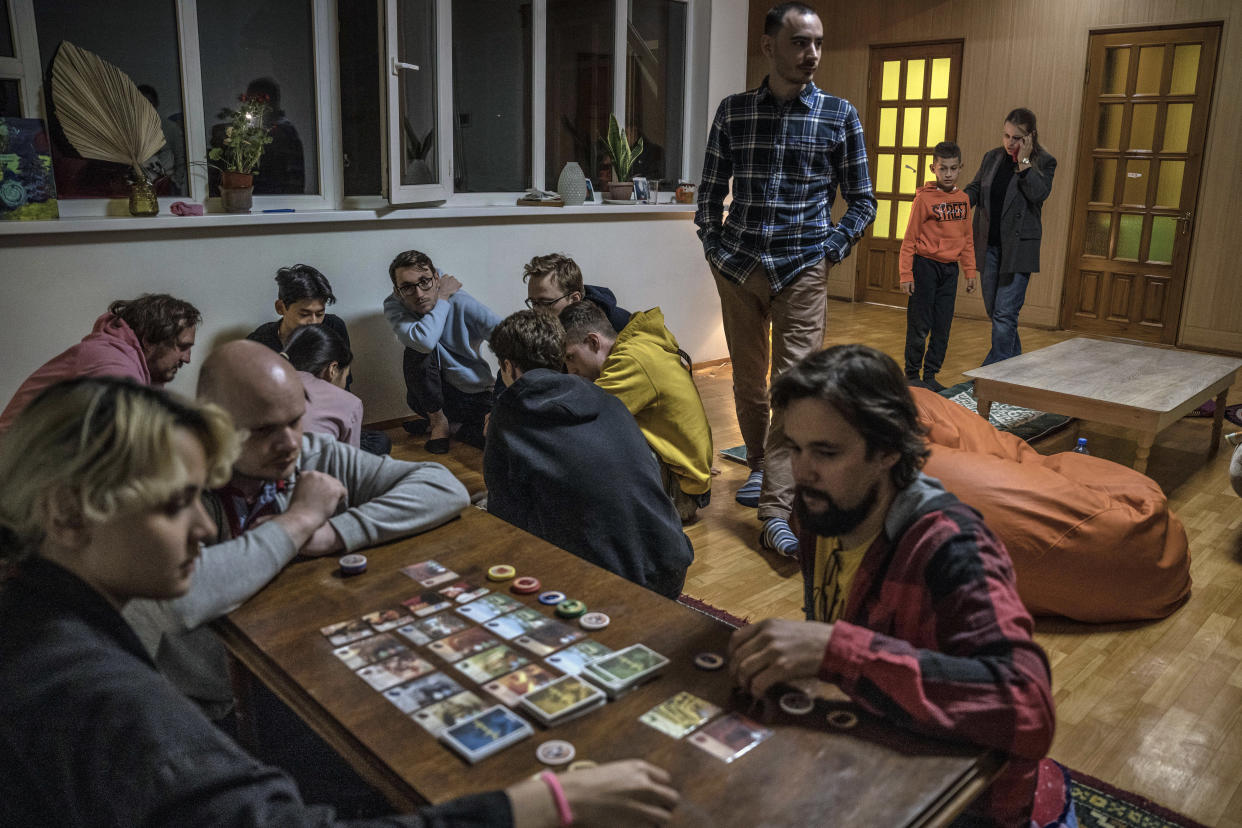 Hombres que huyeron de Rusia participando en un juego de mesa en un hostal de Biskek, Kirguistán, el domingo 2 de octubre de 2022. (Sergey Ponomarev/The New York Times)