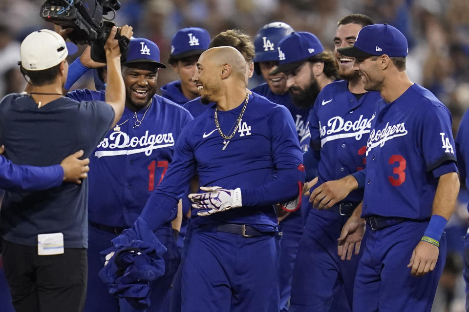 Los Angeles Dodgers' Mookie Betts, center, is greeted by teammates after he hit a walk-off single to win a baseball game 3-2 against the Arizona Diamondbacks in Los Angeles, Thursday, Sept. 22, 2022. Freddie Freeman scored. (AP Photo/Ashley Landis)