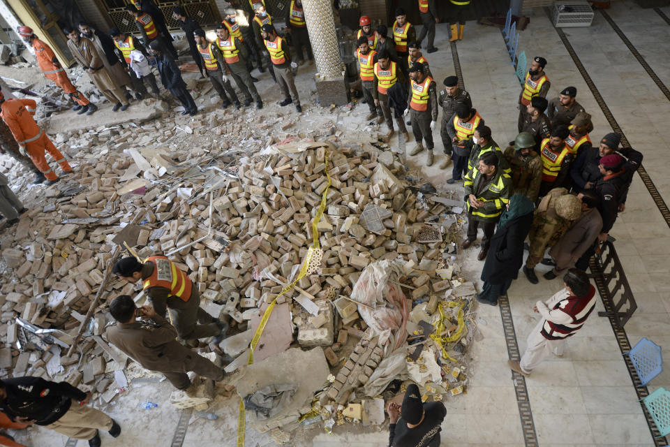 Rescue workers gather as they conduct an operation to clear the rubble and find the bodies at the site of Monday's suicide bombing, in Peshawar, Pakistan, Tuesday, Jan. 31, 2023. The death toll from the previous day's suicide bombing at a mosque in northwestern Pakistani rose to more than 85 on Tuesday, officials said. The assault on a Sunni Mosque inside a major police facility was one of the deadliest attacks on Pakistani security forces in recent years. (AP Photo/Muhammad Zubair)