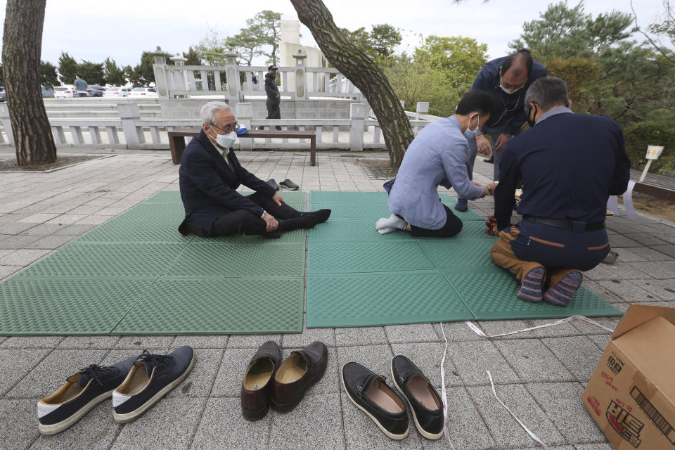 North Korean refugee Jo Kyeong-hyeon, left, and his family members pay respect to their ancestors in North Korea to celebrate the Chuseok, the Korean version of Thanksgiving Day, at Imjingak Pavilion in Paju, near the border with North Korea, South Korea, Thursday, Oct. 1, 2020. The government has discouraged people from visiting their hometowns for the Chuseok holiday amid concerns about the spread of the coronavirus. (AP Photo/Ahn Young-joon)