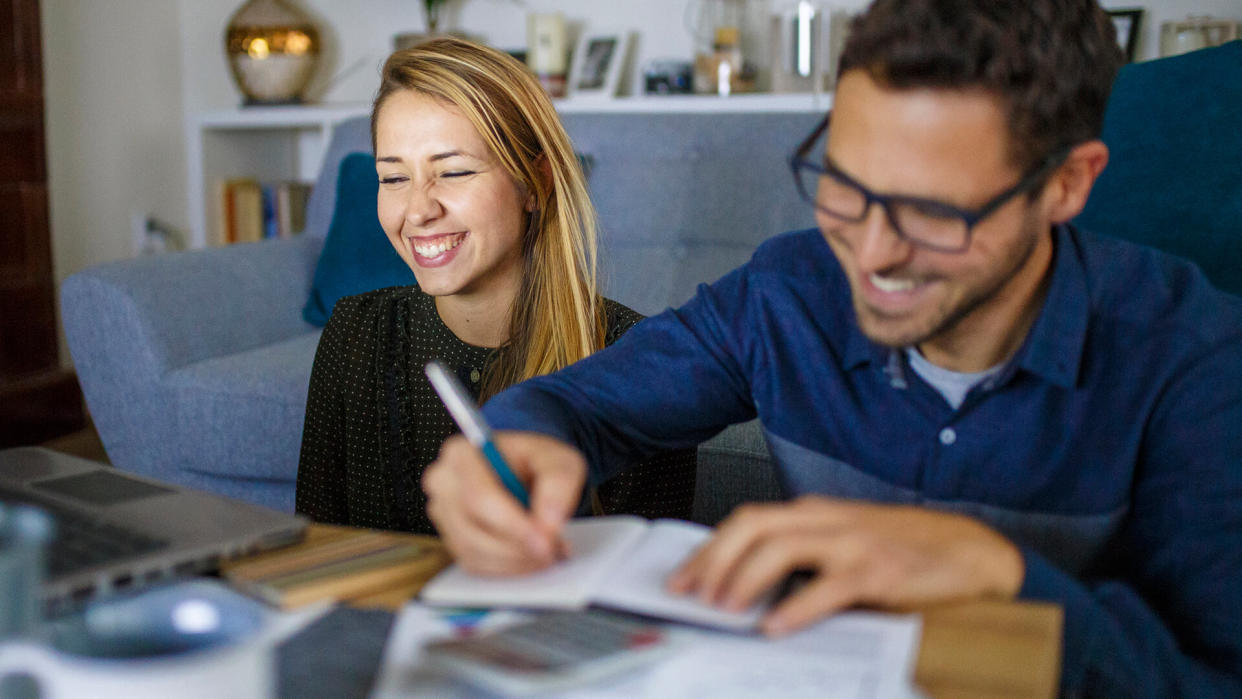 Couple at home sorting through bills and taxes.