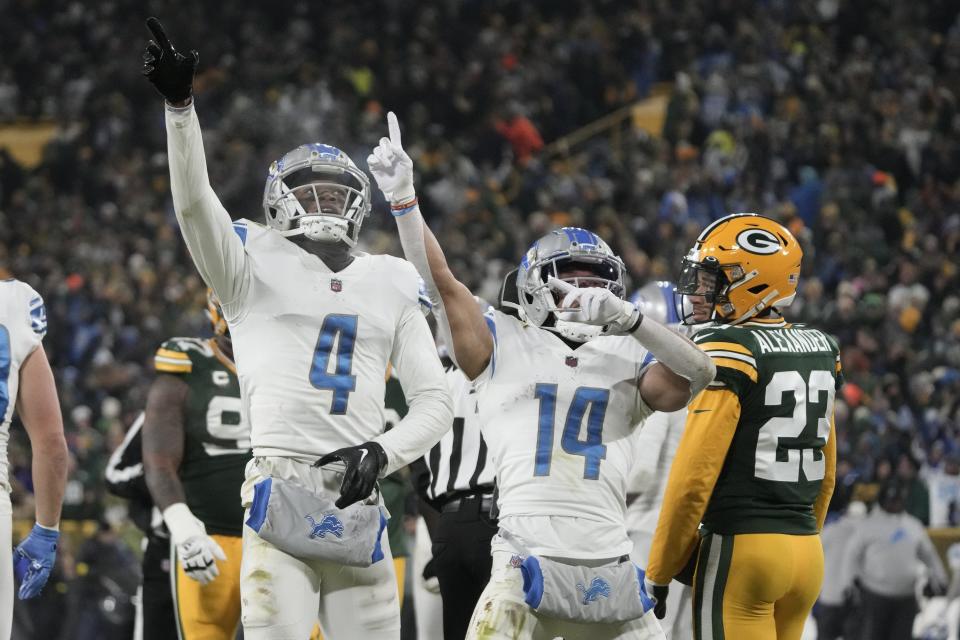 Detroit Lions wide receiver DJ Chark (4) and wide receiver Amon-Ra St. Brown (14) celebrate as Green Bay Packers cornerback Jaire Alexander (23) watches after Chark caught a pass for a first down late in the second half at Lambeau Field in Green Bay, Wisconsin, on Sunday, Jan. 8, 2023.