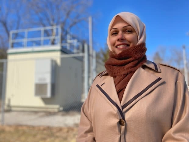 Hind Al-Abadleh, shown in front of an air quality monitoring station in Kitchener, says smoke from wild and forest fires can be a health concern for people in southern Ontario, but it should also spark conversations about the impact climate change has on the intensity and frequency of fires. (Mark Bochsler/CBC - image credit)