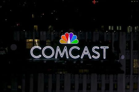 FILE PHOTO - The NBC and Comcast logo are displayed on top of 30 Rockefeller Plaza, formerly known as the GE building, in midtown Manhattan in New York July 1, 2015. The Art Deco skyscraper, also known as '30 Rock' and once displayed a large neon 'GE', unveiled the NBC Peacock logo and Comcast brand-name this week. REUTERS/Brendan McDermid