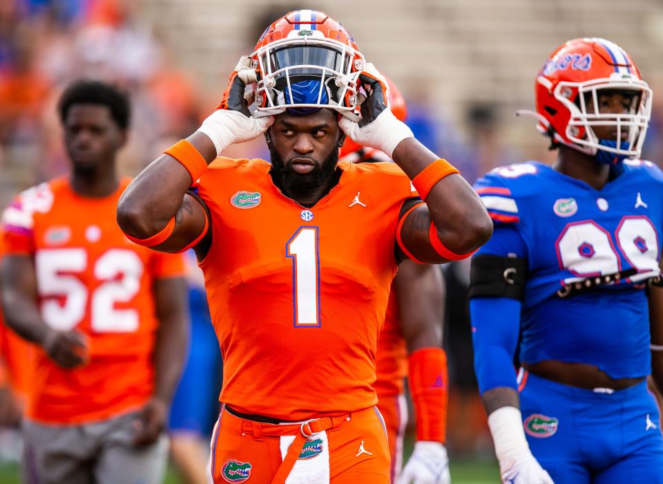 Florida Gators outside linebacker Brenton Cox Jr. (1) puts on his helmet during warm ups. The Florida Gators scrimmaged in the first quarter during the annual Orange and Blue spring game at Ben Hill Griffin Stadium in Gainesville, FL, Thursday afternoon, April 14, 2022. [Doug Engle/Ocala Star Banner]2022