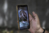 Anil Sharma shows a photograph of his son Saurav who is being treated for COVID-19 at a private hospital in New Delhi, India, Thursday, July 1, 2021. Life is tentatively returning to normal in India as coronavirus cases fall. But millions are embroiled in a nightmare of huge piles of medical bills. Most Indians don't have health insurance and costs for COVID-19 treatment have them drowning in debt. (AP Photo/Manish Swarup)