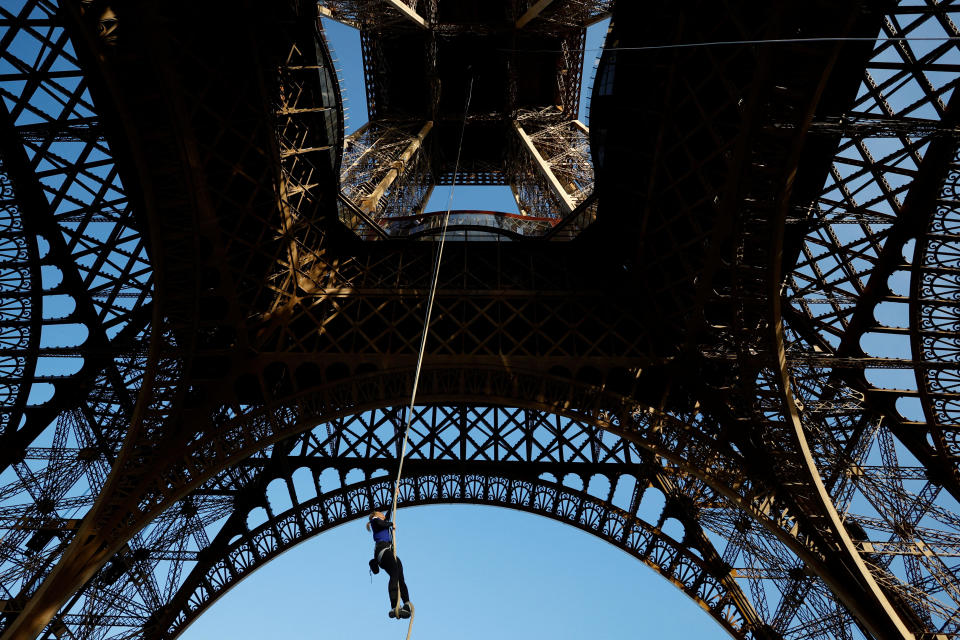 Athlete and Olympics torch bearer Anouk Garnier climbs a 110-meter-long rope launched in the center of the Eiffel Tower square to reach the 2nd floor and to attempt to break the world record for rope climbing, in Paris, France, April 10, 2024. / Credit: Sarah Meyssonnier / REUTERS