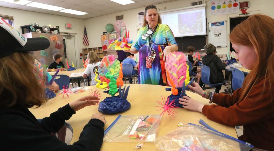 Teacher Dorothy Featherston helps a table of fourth-graders build a coral reef art project, Tuesday, Feb. 28, 2023, at South Daytona Elementary School.