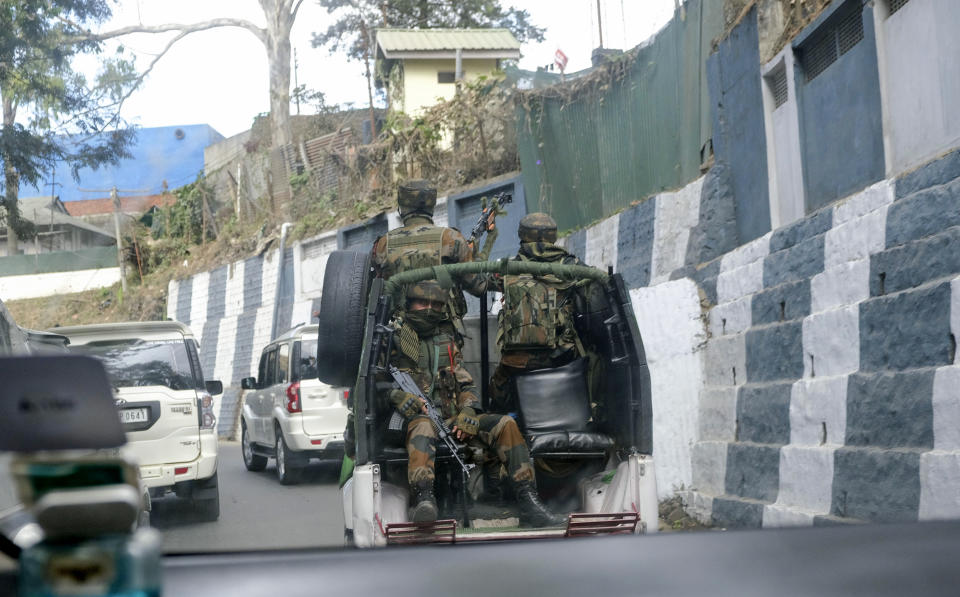 Indian army soldiers ride past the main town in a convoy in Kohima, capital of northeastern Nagaland state, India, Sunday, Dec. 5, 2021. Angry villagers burned army vehicles in protest after more than a dozen people were killed by Indian army soldiers who mistakenly believed some of them were militants in Nagaland state, along the border with Myanmar, about 300 kilometers (186 miles) from here. Nagaland state’s top elected official ordered a probe into the killings, which occurred on Saturday. (AP Photo/Yirmiyan Arthur)