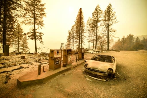 A burnt car and a gas station remain visible on November 11, 2018 after the "Camp" fire tore through the region near Pulga, east of Paradise, California