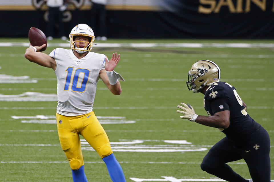 Los Angeles Chargers quarterback Justin Herbert (10) passes under pressure from New Orleans Saints defensive end Cameron Jordan (94) in the first half of an NFL football game in New Orleans, Monday, Oct. 12, 2020. (AP Photo/Butch Dill)